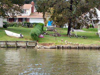 Effects of storm surge flood (cinder blocks carried inland) and ebb (collapse of block wall; scour near motor boat). Middle R., BaltimoreCo. [11]